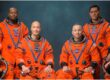Artemis 3 astronauts Andre Douglas, Luca Parmitano, Randy Bresnik and Frank Rubio posing in orange NASA flight suits, Johnson Space Center, June 2026