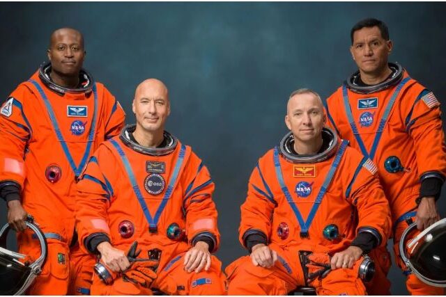 Artemis 3 astronauts Andre Douglas, Luca Parmitano, Randy Bresnik and Frank Rubio posing in orange NASA flight suits, Johnson Space Center, June 2026