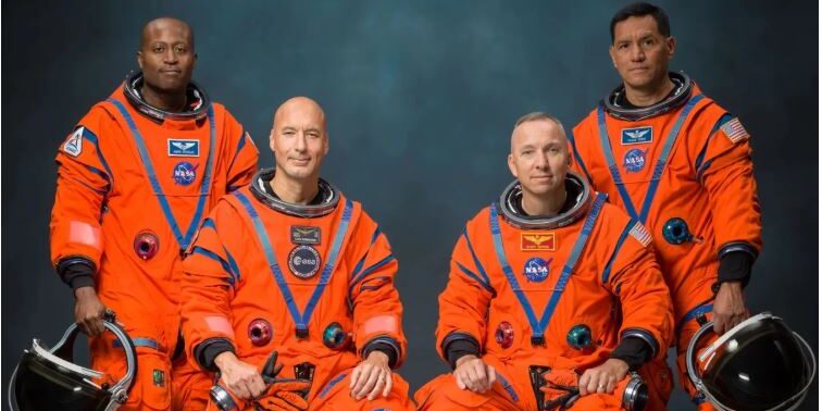 Artemis 3 astronauts Andre Douglas, Luca Parmitano, Randy Bresnik and Frank Rubio posing in orange NASA flight suits, Johnson Space Center, June 2026